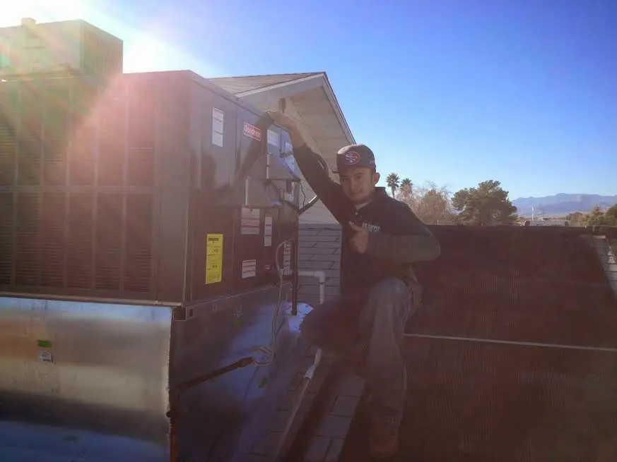 HVAC technician performing AC Tune-Up on a rooftop unit in South Fayette